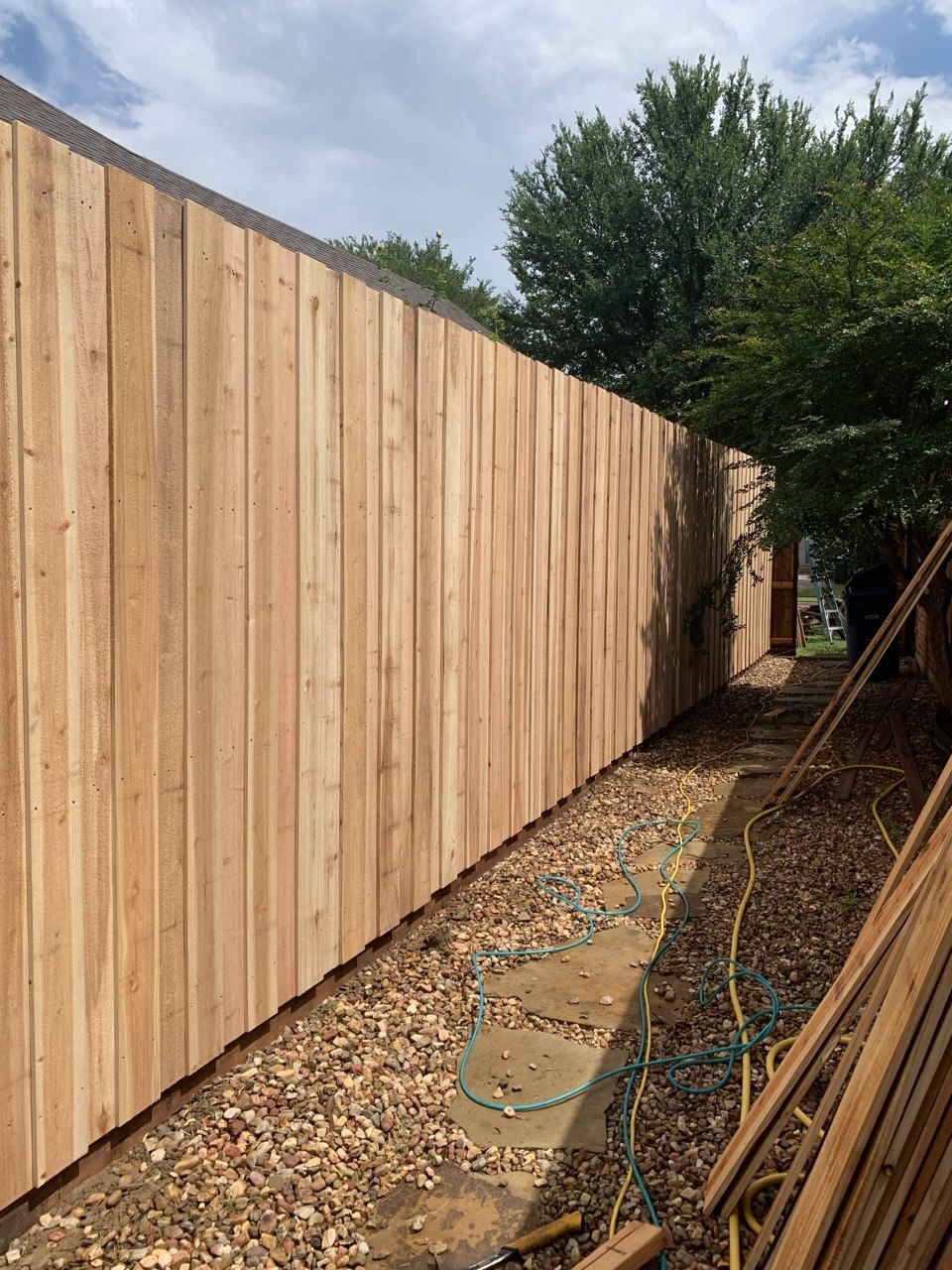 Raw natural cedar board on board fence line before staining