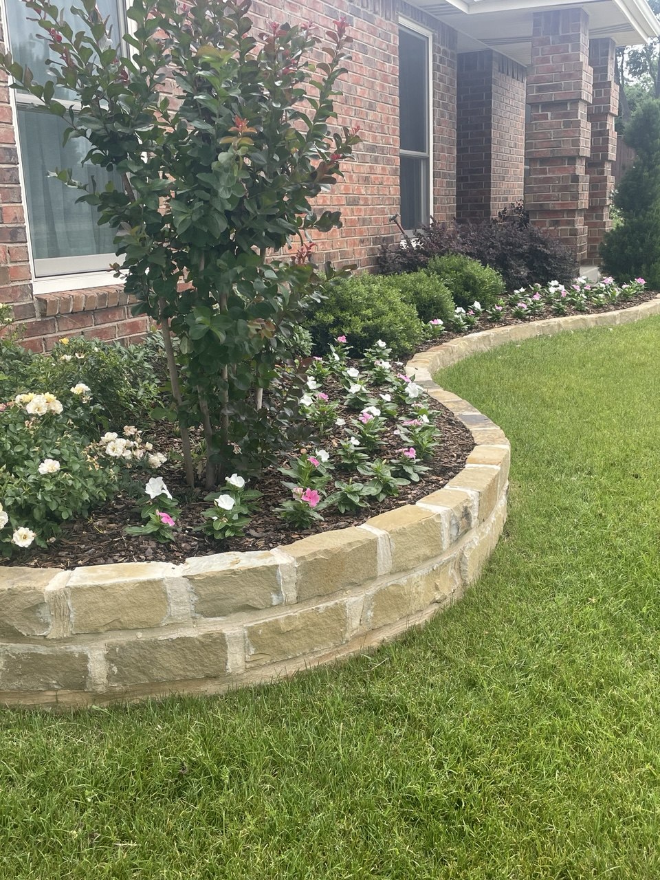 Curved natural stone garden bed border and edging around a flower bed